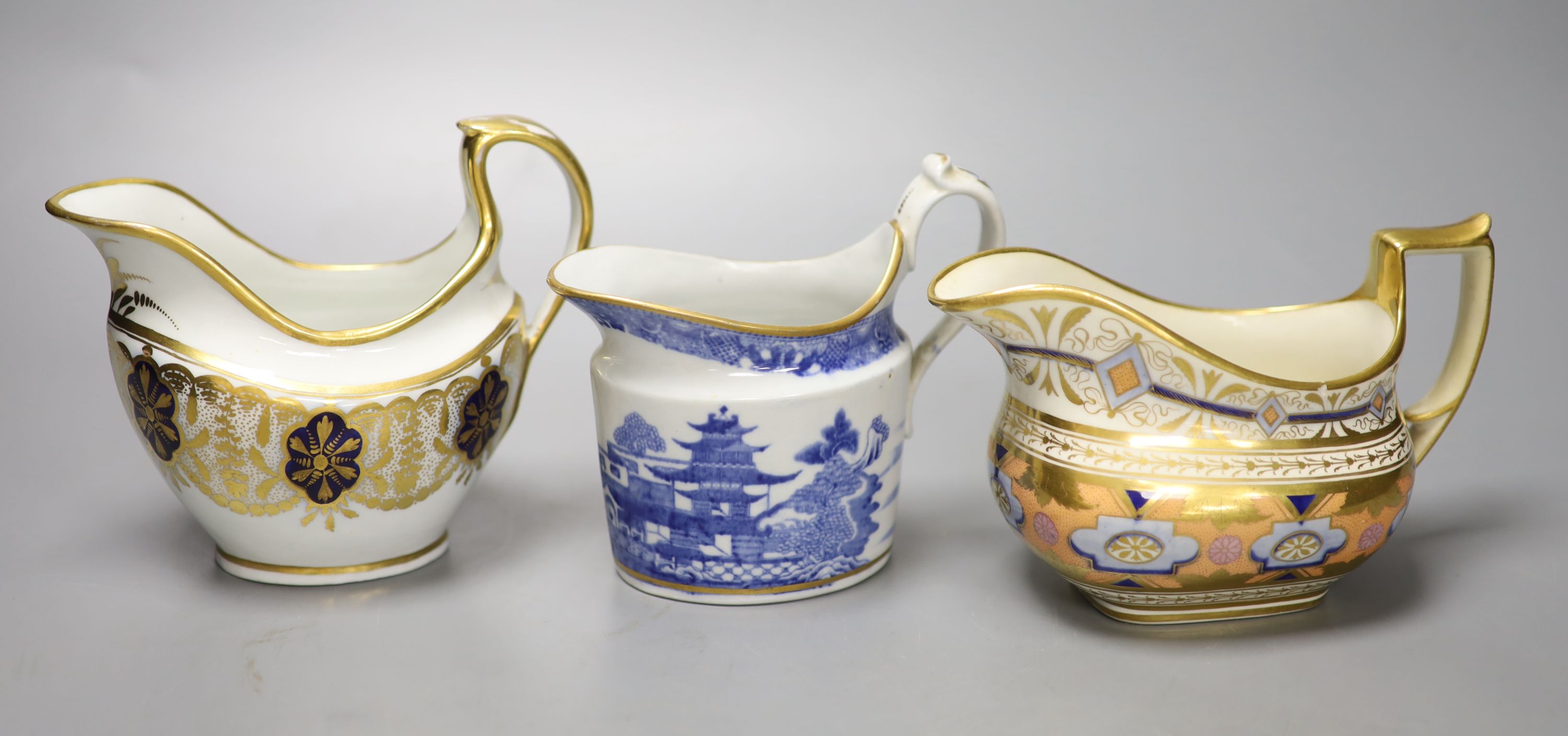 A Coalport hybrid hard paste cream jug in blue and gilt, a Miles Mason blue and gilt cream jug, impressed M. Mason, and a Ridgway cream